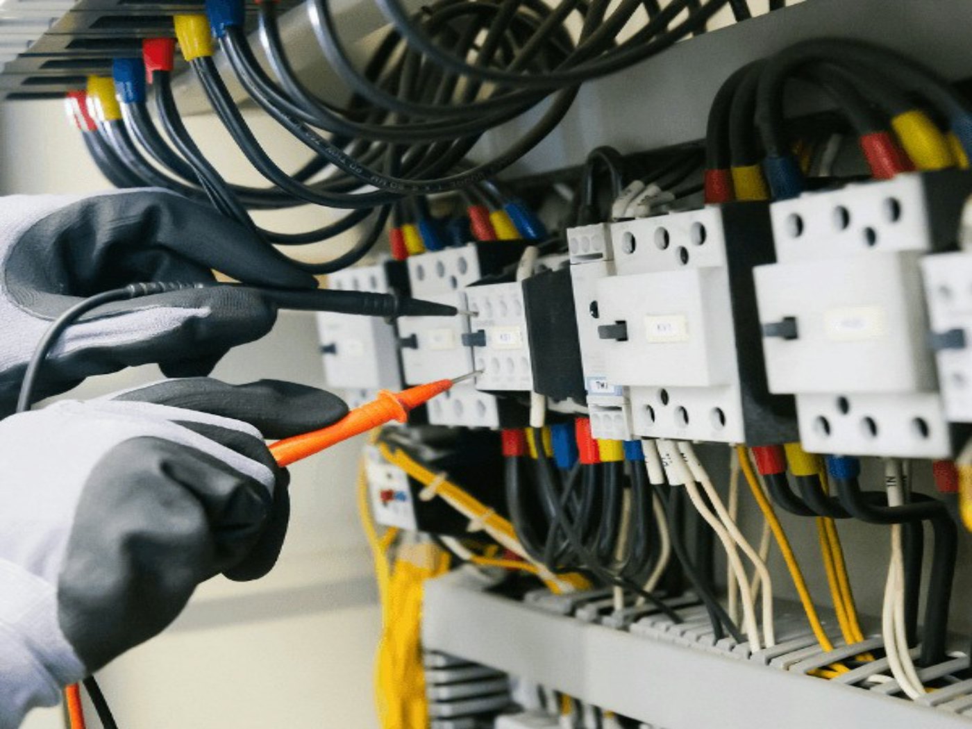 Engineer testing a control panel with a multimeter